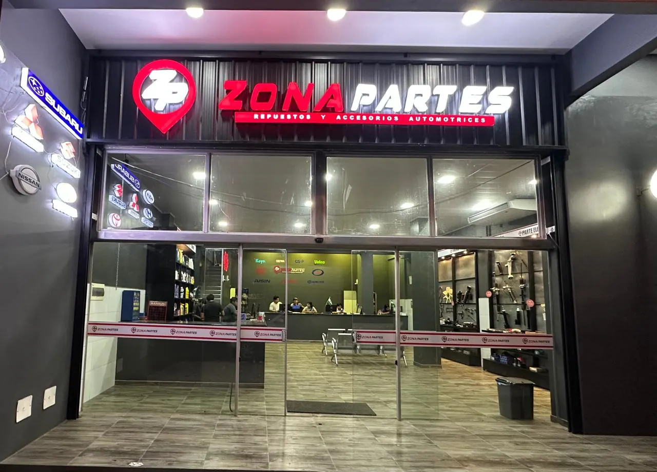 La tienda de Zona Parts de noche, con su letrero luminoso